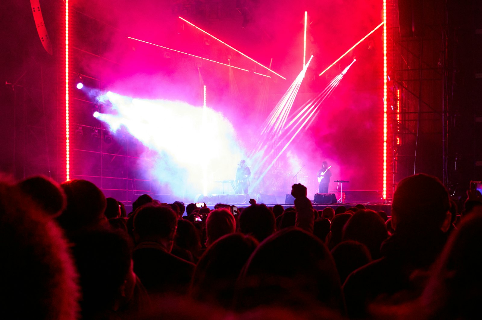 Konzertbühne mit pinker Lichtshow und Publikum